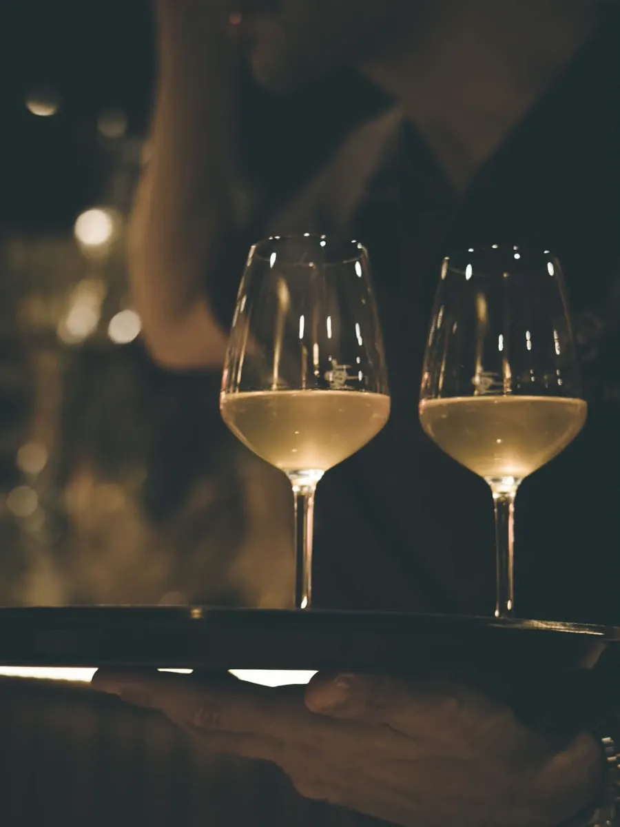 Deux verres de vin blanc servis sur un plateau.