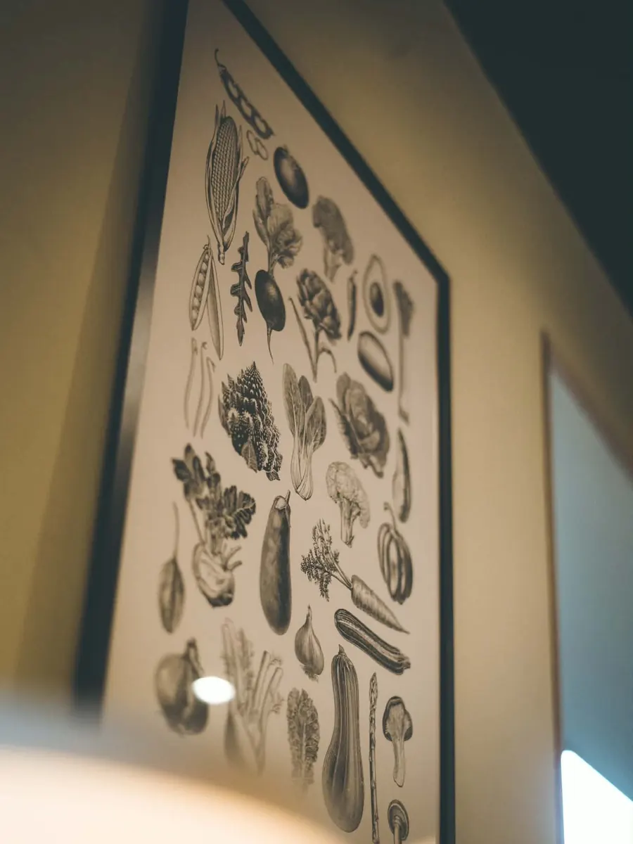 Une affiche de légumes anciens dessinés à l’encre, au mur de la salle.